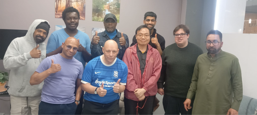 Group photo of men with smiles and thumbs up